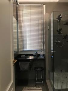 a bathroom with a sink and a shower and a stool at Habitación grande y confortable con baño privado junto a Guggenheim in Bilbao