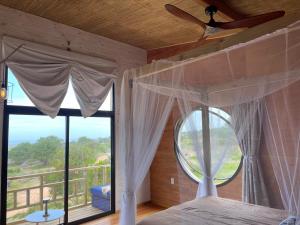 sypialnia z łóżkiem i dużym oknem w obiekcie Eco Boutique B&B w mieście Punta del Diablo