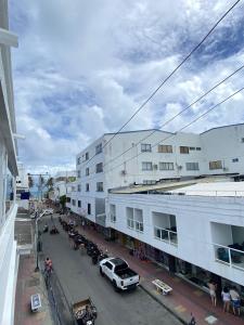 uma rua da cidade com carros estacionados em frente aos edifícios em Holiday Sai Hotel em San Andrés