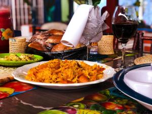 a table with a plate of food and a glass of wine at Hospedaje Valentina para ti y tu familia in Mera