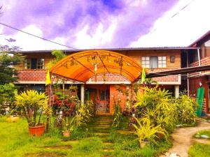 a house with an arbor and plants in front of it at Hospedaje Valentina para ti y tu familia in Mera