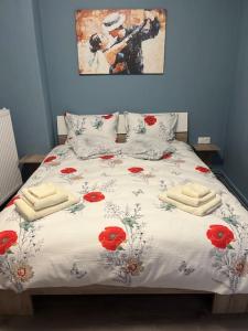 Un dormitorio con una cama con flores rojas. en Casa Kleisoura, en Klisoúra