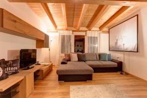 ein Wohnzimmer mit einem Sofa und einem TV in der Unterkunft Haus Mattle in Pettneu am Arlberg