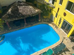 ein großer blauer Pool neben einem Gebäude in der Unterkunft Coco Hotel and Hostel in Sosúa