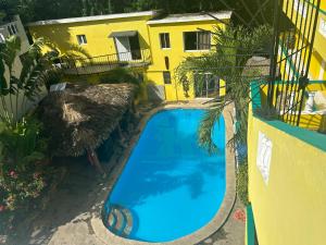 an overhead view of a swimming pool in front of a yellow building at Coco Hotel and Hostel in Sosúa