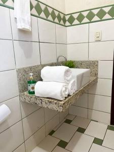 a bathroom with a sink and towels on a shelf at Casa conforto e estilo in Palmas