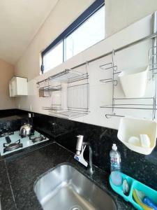 uma bancada de cozinha com um lavatório e uma janela em Casa conforto e estilo em Palmas