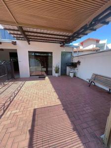 a brick patio with a bench and a building at Casa conforto e estilo in Palmas