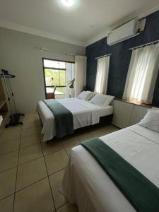 a hotel room with two beds and a window at Casa conforto e estilo in Palmas +9 photos