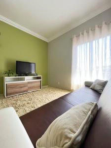 ein Schlafzimmer mit einem großen Bett und einem TV in der Unterkunft Casa conforto e estilo in Palmas