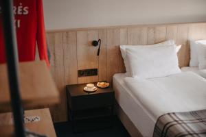 a hotel room with a bed and a table with a plate of food at Alpina Hotel in Gudauri