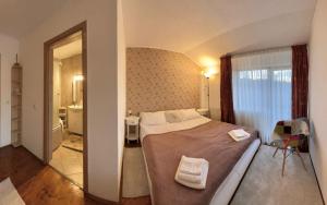 a bedroom with a large bed and a bathroom at Casuta cu amintiri in Cîmpulung