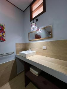 y baño con lavabo y espejo. en AmimodoBeachRooms, en Puerto Viejo