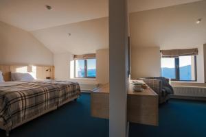 a hotel room with a bed and a desk and windows at Alpina Hotel Gudauri in Gudauri +51 photos