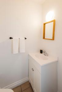 uma casa de banho com um lavatório branco e um espelho. em Yellowknife Downtown 50a ave Vacation Home em Yellowknife