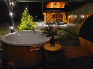 einen Whirlpool mit einem Weihnachtsbaum und einem Haus in der Unterkunft Sosnowy Zakątek in Józefów