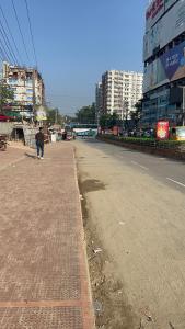 a person walking down a street in a city at World beach resort in Cox's Bazar