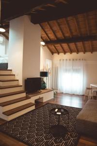 uma sala de estar com uma escada e um sofá em Albinelli's Apartment - 10m from mercato Albinelli em Módena