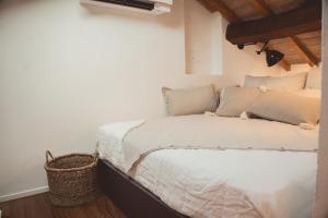 um quarto com uma cama branca e uma cesta em Albinelli's Apartment - 10m from mercato Albinelli em Módena