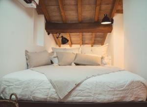 um quarto com uma cama branca e um tecto de madeira em Albinelli's Apartment - 10m from mercato Albinelli em Módena