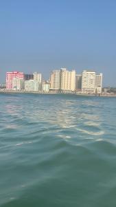 a large body of water with buildings in the background at World beach resort in Cox's Bazar