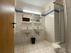 a bathroom with two sinks and a mirror at Twenty Seven Budget Hotel in Zell am See