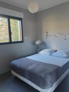 Gîte de charme في Barbazan: غرفة نوم بسرير وبطانية زرقاء ونافذة