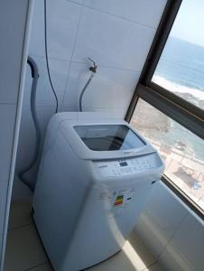 lavadora en una habitación con ventana en frente a la playa vista preciosa 3 habitaciones 2 baños, en Iquique