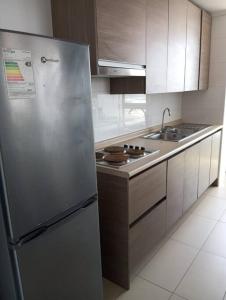 uma cozinha com um frigorífico de aço inoxidável e um lavatório em frente a la playa vista preciosa 3 habitaciones 2 baños em Iquique