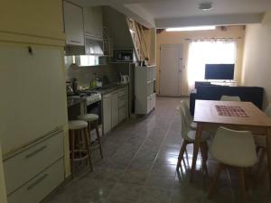 a kitchen with a table and chairs and a dining room at Duplex Marea Baja in Playa Unión +12 photos