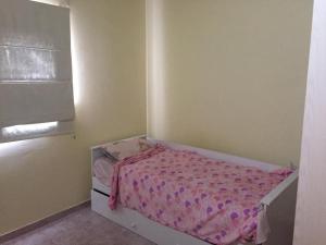 a small bedroom with a bed with a pink blanket at Duplex Marea Baja in Playa Unión