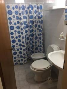 a bathroom with a toilet and a shower curtain at Duplex Marea Baja in Playa Unión