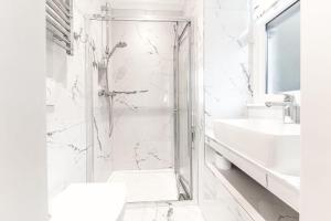 a white bathroom with a shower and a sink at 1 Brathay Fell in Ambleside +24 photos