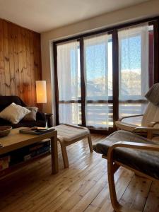 a living room with a couch and some windows at Casa Polsa, 280 m Piste in Prada
