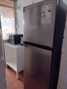 una nevera congelador sentada en una cocina junto a un mostrador en Casa Foresta Curicó, en Curicó