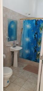 baño con lavabo y cortina de ducha azul en HOSPEDAJE DELFIN AZUL, en Puerto Villamil