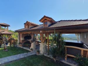a large wooden pavilion with a fireplace in a yard at Domus Antiqua in Gornja Voća