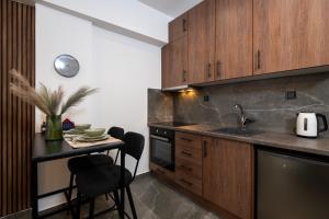 a kitchen with wooden cabinets and a table with a sink at LP Citycenter Suite in Serres