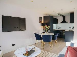 Stylish Retreat for Your Short Getaway في لندن: مطبخ وغرفة معيشة مع طاولة وكراسي