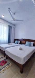 two large beds in a bedroom with a ceiling at vienna Greenwood 3bd massionate mombasa pool.deck wifi in Mtwapa