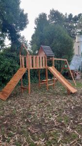 einen Holzspielplatz mit Rutsche im Hof in der Unterkunft LA ARBOLADA in Mar del Plata