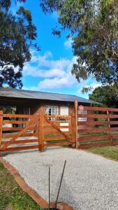 ein Holzzaun vor einem Haus in der Unterkunft LA ARBOLADA in Mar del Plata