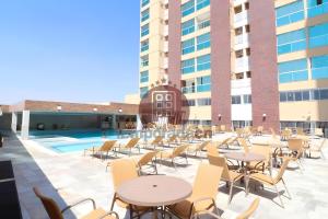 an outdoor patio with tables and chairs and a pool at Piazza diRoma com acesso ao Acqua Park - Temporada CN in Caldas Novas