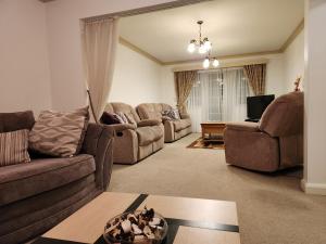 uma sala de estar com dois sofás e uma televisão em Elmdon House with 4 Spacious Bedrooms to choose em Birmingham