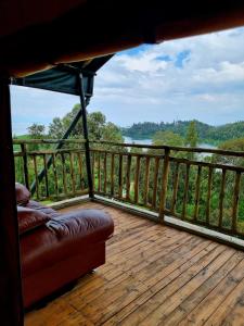 a porch with a couch on a deck with a view at Mzinga Retreat in Gitesi