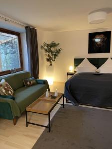a bedroom with a bed and a couch and a table at WALDWERK am Wasserfall in Triberg