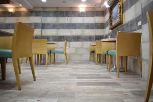 una sala da pranzo con sedie e tavoli in legno di Nour Hotel ad Amman