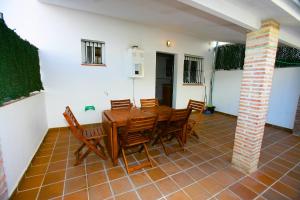 een eetkamer met een houten tafel en stoelen bij Casa Rural Rafael Alberti in El Bosque