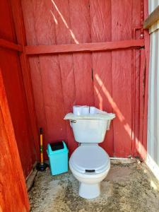 a toilet in a red barn with a red wall at Rustico Arenal B&B in Fortuna