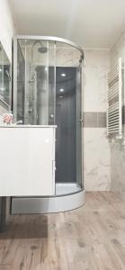 La salle de bains est pourvue d'une douche avec une porte en verre. dans l'établissement Appartement au rez-de-chaussée avec jardin privé, à Margny-lès-Compiègne